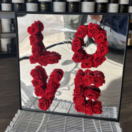Red roses arranged as the numbers 1, 0, 1, and 5 in a mirrored frame
