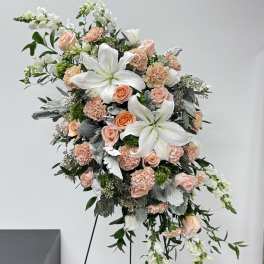 Tall floral spray with white lilies and blush roses on a stand