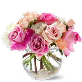 Pink and peach roses arranged in a clear glass vase