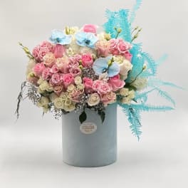 Pink and white rose bouquet in a pale blue box with blue accents