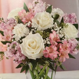 Pink and white bouquet of roses and alstroemeria in a clear glass vase