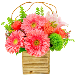 Pink gerbera daisies and orange roses in a wooden box with a twig handle