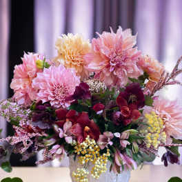 Pink and peach floral arrangement in a white textured vase