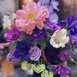 Bouquet of pink, purple, and white flowers with a large peach bloom