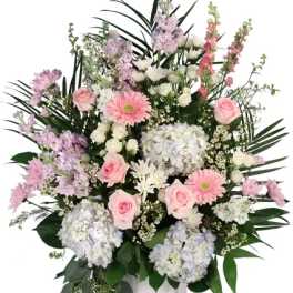 Pink and white floral arrangement in a white urn vase