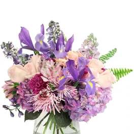 Purple and pink mixed bouquet in a clear glass vase