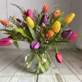 Colorful tulips arranged in a clear glass vase