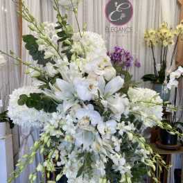 Large white floral standing arrangement with orchids and lilies