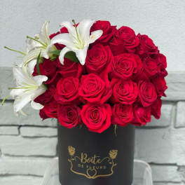 Red roses with white lilies in a black hat box