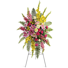 Tall standing floral spray with pink, yellow, and white flowers on an easel