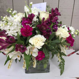 White and magenta mixed bouquet in a square glass vase