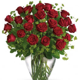 Red roses arranged in a clear glass vase