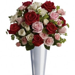Bouquet of red, pink, and white roses in a silver vase