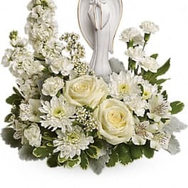 White floral arrangement with an angel figurine centerpiece