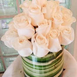 Bouquet of pale cream roses in a striped green vase
