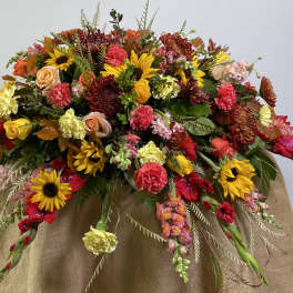 Large mixed floral arrangement with sunflowers, roses, and carnations