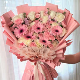 Large pink bouquet with roses, gerbera daisies, and carnations wrapped in pink paper