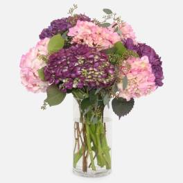 Pink and purple hydrangea bouquet in a clear glass vase