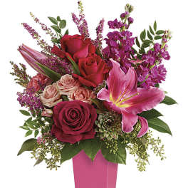 Bouquet of red and pink flowers in a tall pink vase