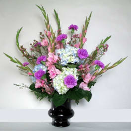 Pink and purple floral arrangement in a black vase