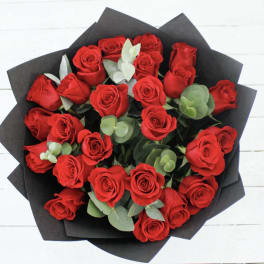 Bouquet of red roses wrapped in black paper