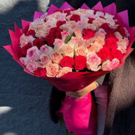 Large bouquet of pink and red roses wrapped in bright pink paper
