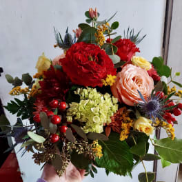 Mixed bouquet with red, peach, and yellow roses and hydrangea