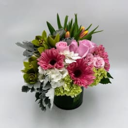 Pink roses and gerbera daisies arranged in a dark vase