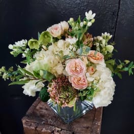 Blush and white floral arrangement in a square glass vase
