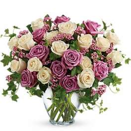Pink and white roses arranged in a clear glass vase