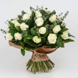 Bouquet of white roses with eucalyptus and brown paper wrap