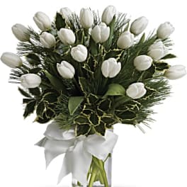 White tulips arranged in a clear glass vase with a white ribbon