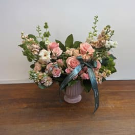 Pink rose bouquet in a ribbed vase with a teal ribbon
