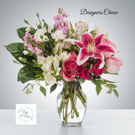 Mixed pink and white flowers arranged in a clear glass vase
