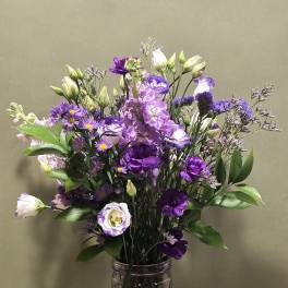 Purple and white bouquet in a glass vase