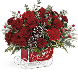 Red roses arranged in a sleigh-shaped container with pinecones and berries