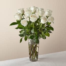 White roses arranged in a clear glass vase