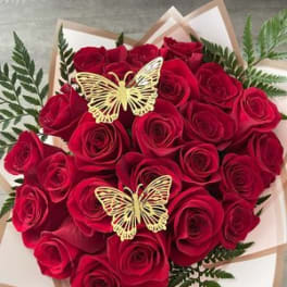 Bouquet of red roses with butterfly accents in white wrapping