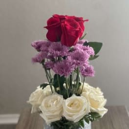 Red and white roses arranged in a glittery glass vase
