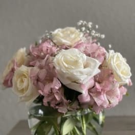 Pink and white roses with pink hydrangeas in a glass vase