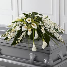 White floral casket spray with calla lilies and orchids