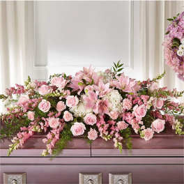 Pink floral arrangement on top of a casket