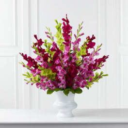 Pink and magenta flowers arranged in a white vase