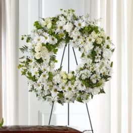 White floral wreath on a black easel