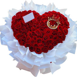 Heart-shaped bouquet of red roses wrapped in white paper