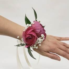 Pink floral wrist corsage with white baby's breath and ribbon