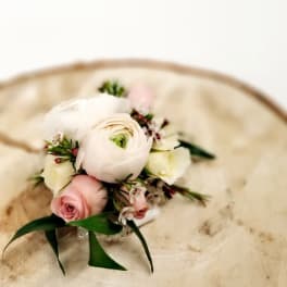 Small bouquet of white and pink flowers on a cream chair