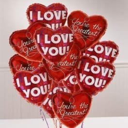 Cluster of red heart-shaped balloons with love messages