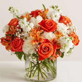 Orange and white mixed bouquet in a clear glass vase
