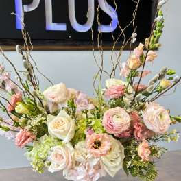 Pastel floral arrangement in a gold pedestal vase